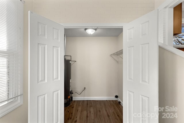 laundry area featuring dark hardwood / wood-style flooring and gas water heater