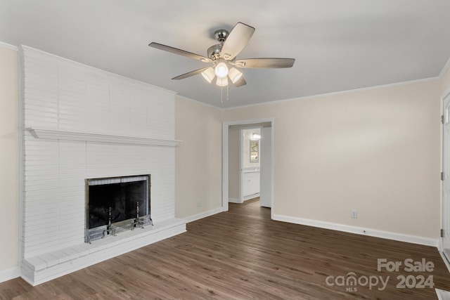 unfurnished living room featuring ceiling fan, dark hardwood / wood-style flooring, ornamental molding, and a brick fireplace