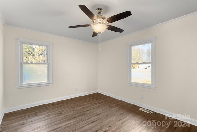 empty room with ceiling fan, dark hardwood / wood-style floors, and ornamental molding