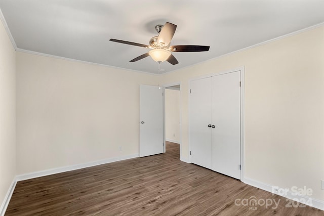 unfurnished bedroom featuring hardwood / wood-style floors, ceiling fan, ornamental molding, and a closet