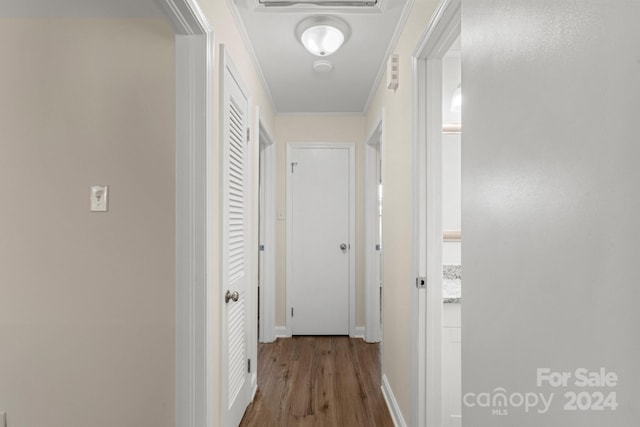 hall with wood-type flooring and crown molding