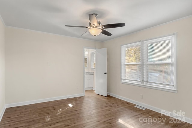 empty room featuring hardwood / wood-style flooring, ceiling fan, and crown molding