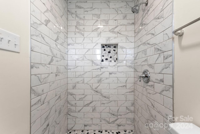 bathroom with tiled shower and toilet