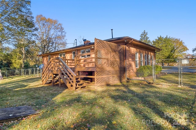 back of house featuring a lawn and a deck