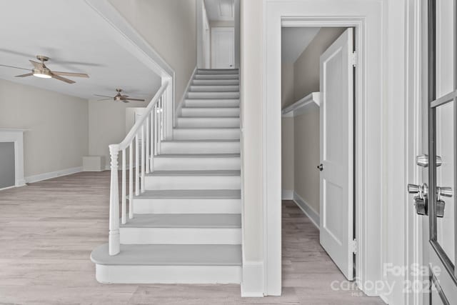 stairs with hardwood / wood-style floors, ceiling fan, and lofted ceiling