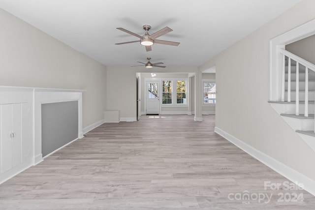 unfurnished living room featuring light hardwood / wood-style flooring and ceiling fan