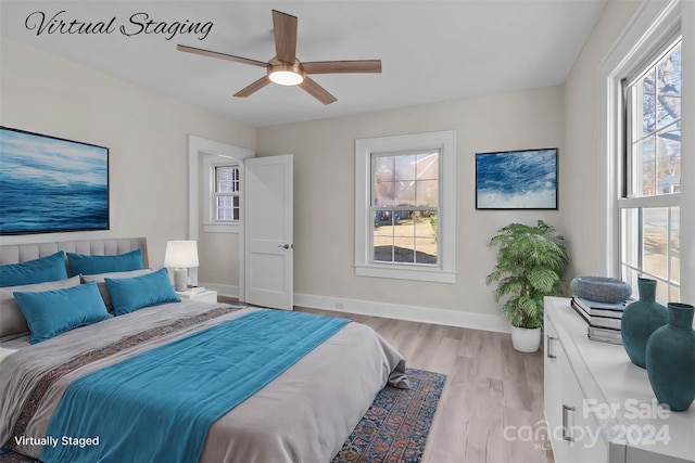 bedroom featuring multiple windows, ceiling fan, and light hardwood / wood-style flooring