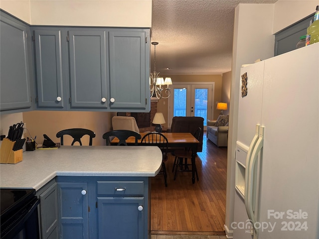 kitchen with white fridge with ice dispenser, an inviting chandelier, black electric range oven, dark hardwood / wood-style floors, and a textured ceiling