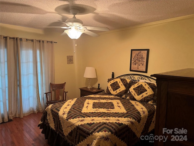 bedroom featuring ceiling fan, dark wood-type flooring, and a textured ceiling