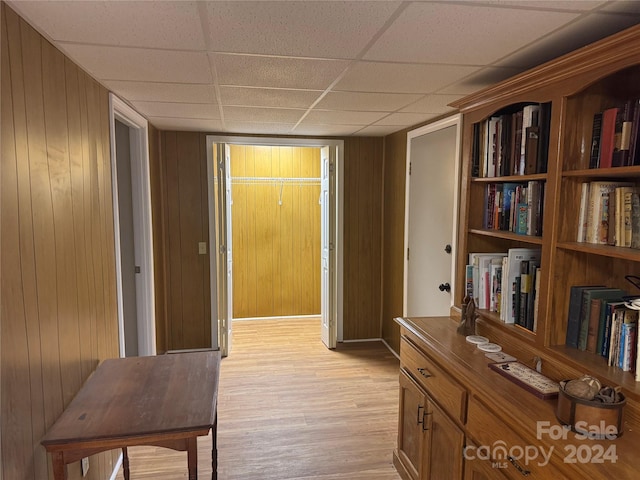 hallway featuring wooden walls and light hardwood / wood-style flooring