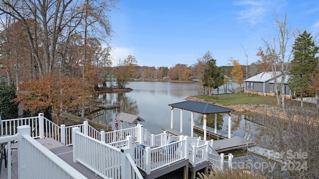 dock area featuring a lawn and a deck with water view