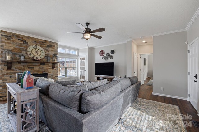 living room with a fireplace, ceiling fan, dark hardwood / wood-style flooring, and ornamental molding