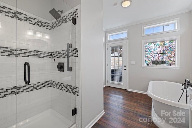 bathroom with hardwood / wood-style floors, crown molding, and plus walk in shower