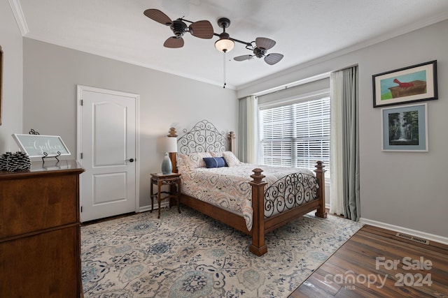 bedroom with hardwood / wood-style floors, ceiling fan, and ornamental molding