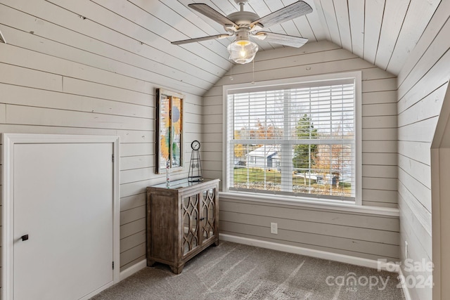 interior space featuring wooden walls, ceiling fan, wood ceiling, and vaulted ceiling