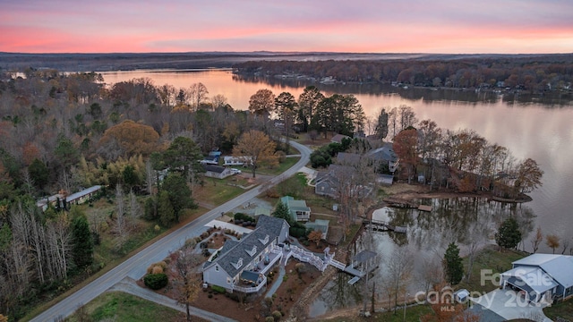 aerial view at dusk featuring a water view