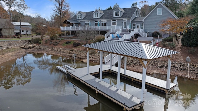 dock area featuring a gazebo and a deck with water view