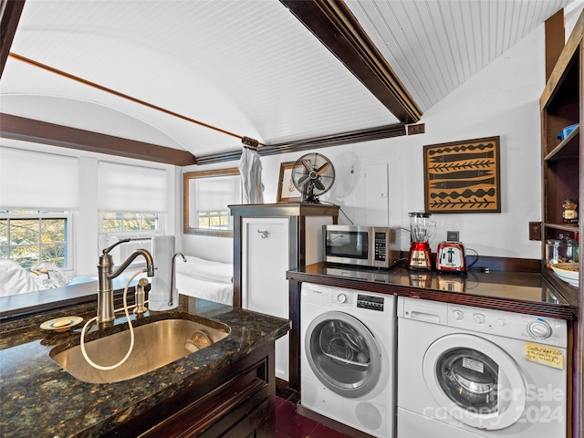 clothes washing area featuring washer and dryer, dark tile patterned flooring, wood ceiling, and sink