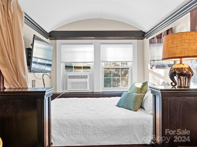 bedroom with hardwood / wood-style floors, cooling unit, and lofted ceiling