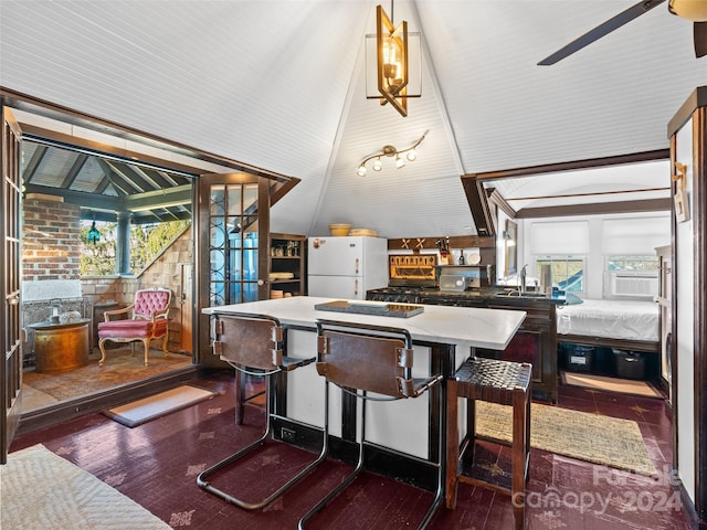 dining room with ceiling fan, sink, lofted ceiling, and dark wood-type flooring