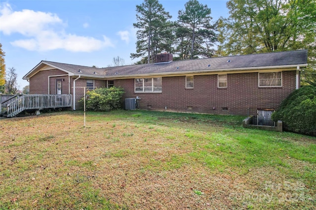 rear view of house featuring a lawn, central AC, and a wooden deck