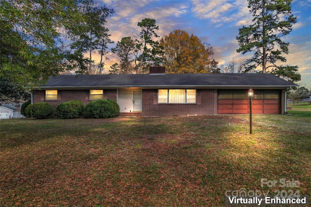 single story home with a garage and a yard