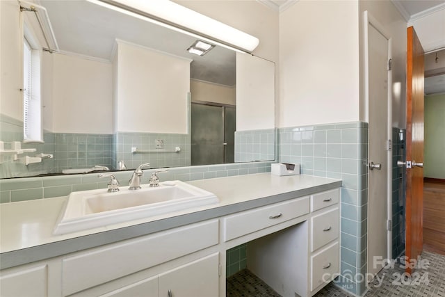 bathroom with crown molding, vanity, and tile walls