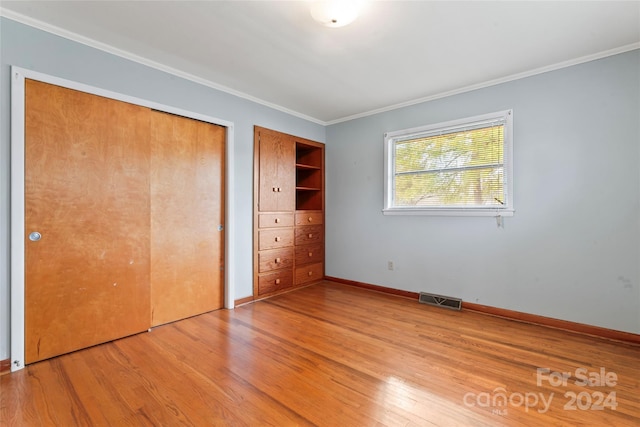 unfurnished bedroom with crown molding and light hardwood / wood-style flooring