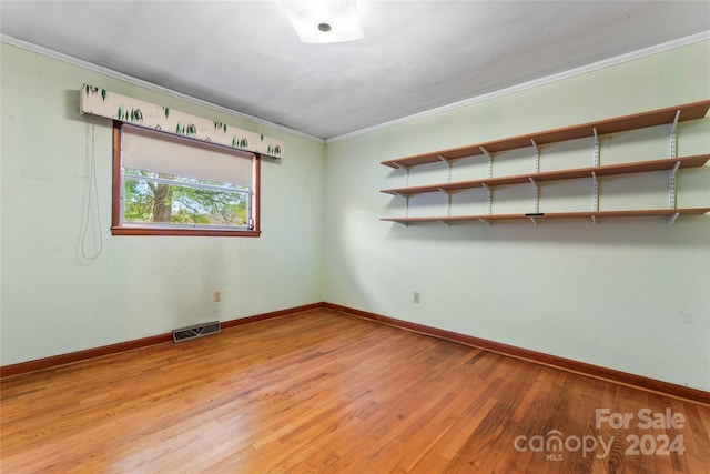 empty room featuring light hardwood / wood-style flooring and ornamental molding