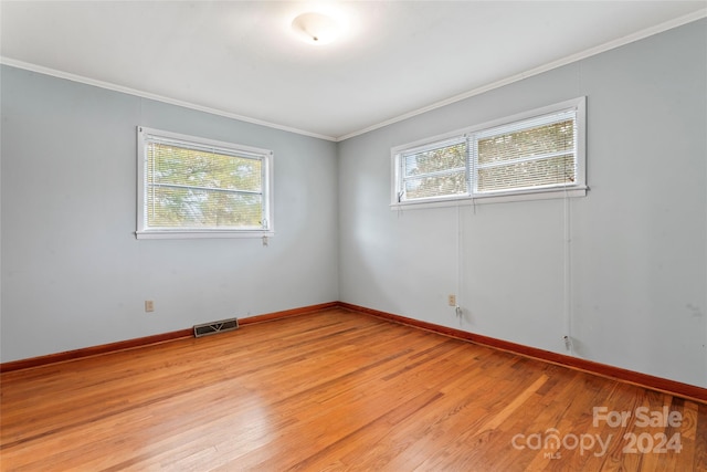 unfurnished room featuring light hardwood / wood-style flooring, a healthy amount of sunlight, and crown molding