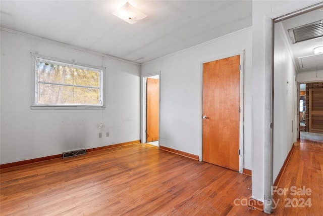 unfurnished bedroom with light wood-type flooring, a closet, and ornamental molding