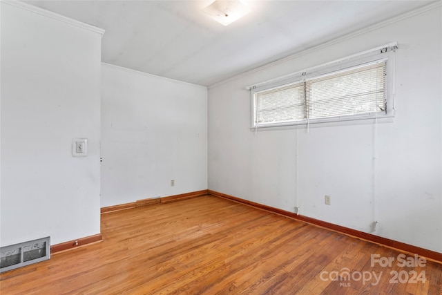 empty room featuring light hardwood / wood-style floors and ornamental molding