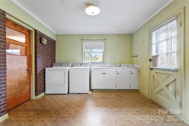 clothes washing area with washer and clothes dryer, a healthy amount of sunlight, cabinets, and ornamental molding