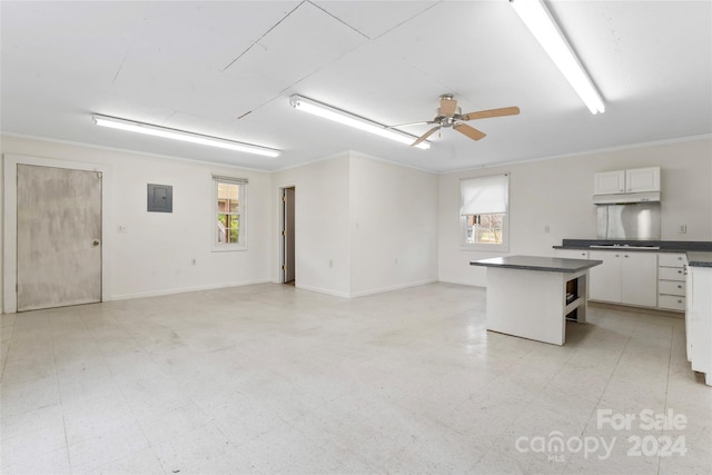 kitchen with electric panel, a wealth of natural light, white cabinets, and stainless steel gas cooktop