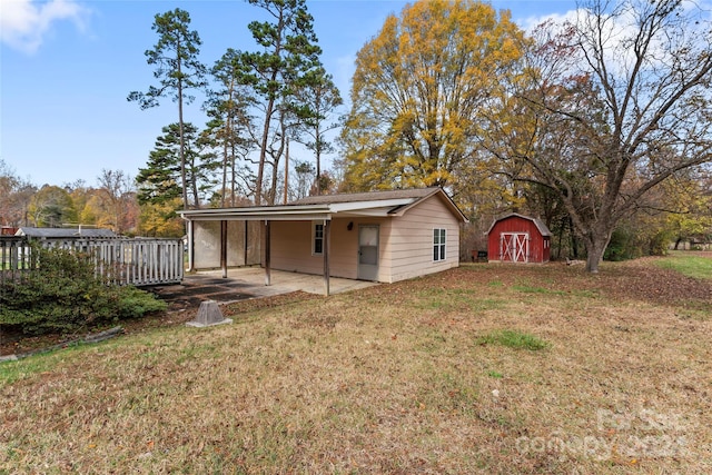 exterior space featuring a patio, a shed, a lawn, and a wooden deck