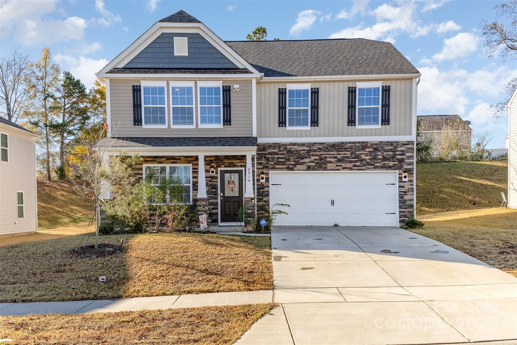 craftsman-style house featuring a front lawn and a garage