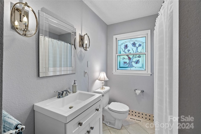 bathroom with vanity, a textured ceiling, tile patterned floors, and toilet