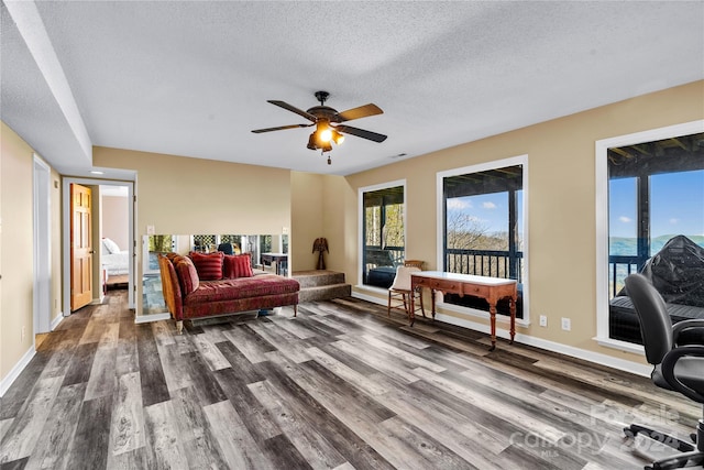 living room with ceiling fan, a textured ceiling, and hardwood / wood-style flooring