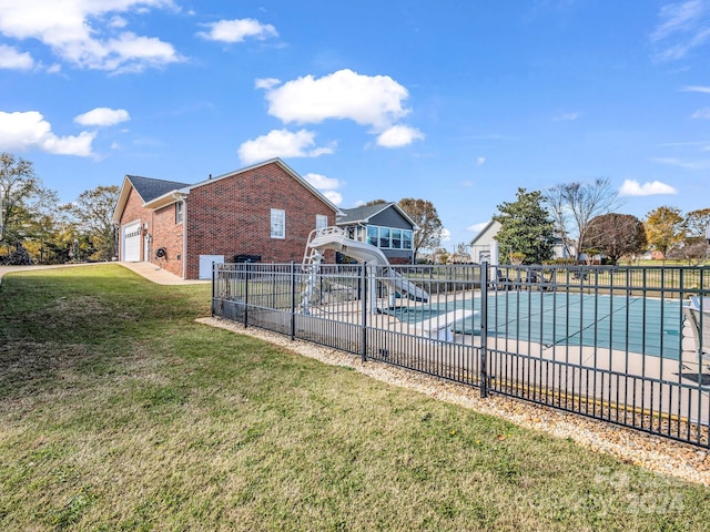 view of pool featuring a lawn, a patio area, and a water slide