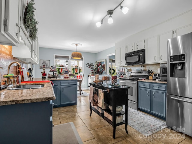 kitchen with blue cabinetry, white cabinetry, sink, pendant lighting, and appliances with stainless steel finishes