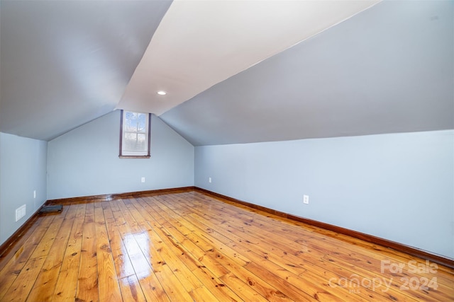 additional living space with lofted ceiling and light wood-type flooring