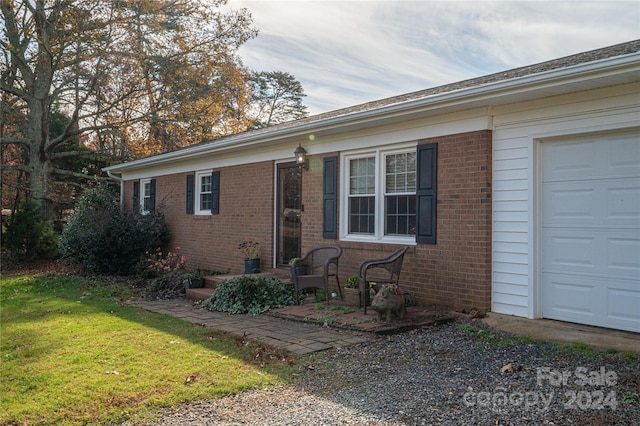 ranch-style home with a garage and a front lawn