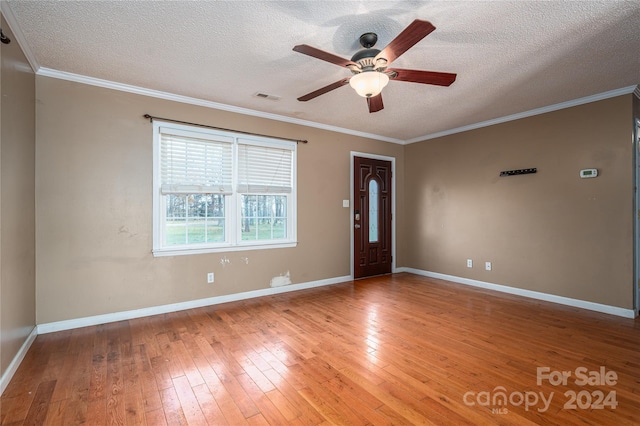 entrance foyer with hardwood / wood-style floors, ceiling fan, ornamental molding, and a textured ceiling