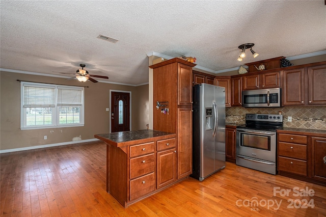 kitchen with stainless steel appliances, tasteful backsplash, crown molding, a textured ceiling, and light wood-type flooring