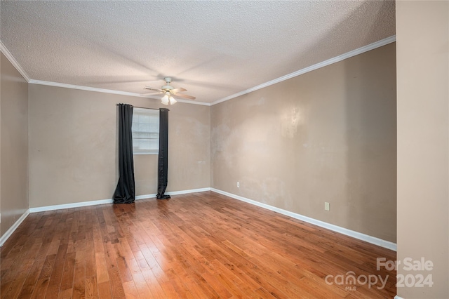 empty room with ceiling fan, hardwood / wood-style floors, a textured ceiling, and ornamental molding