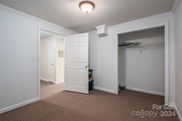 unfurnished bedroom featuring carpet floors, crown molding, and a closet