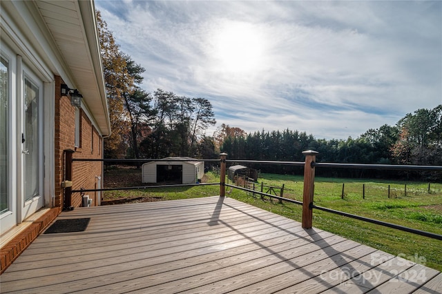 wooden terrace featuring a lawn and a storage shed