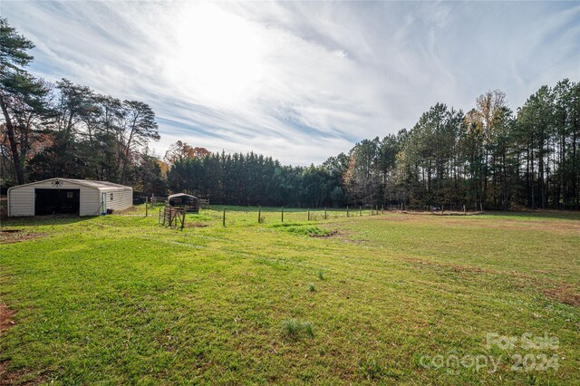 view of yard with an outbuilding and a rural view