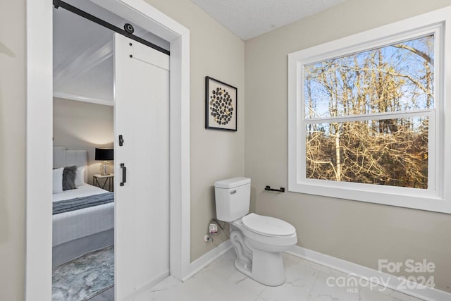 bathroom featuring a textured ceiling and toilet