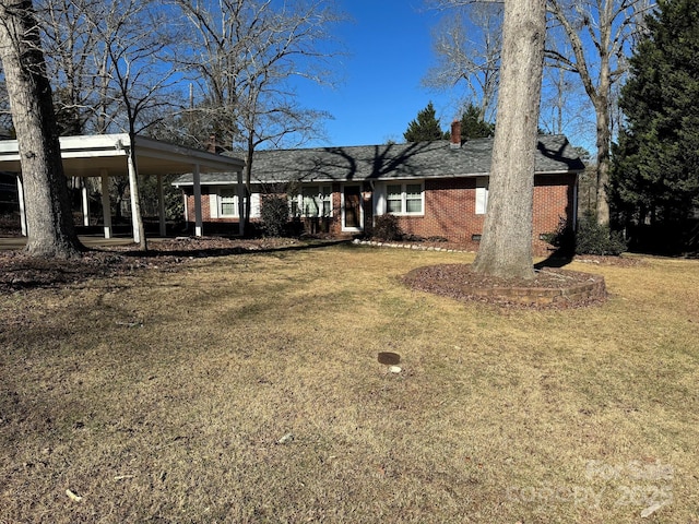 single story home featuring a carport and a front lawn